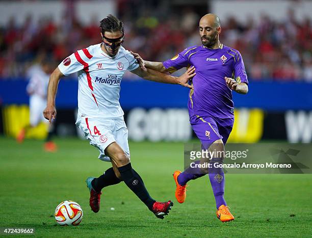 Grzegorz Krychowiak of Sevilla is challenged by Borja Valero of Fiorentina during the UEFA Europa League Semi Final first leg match between FC...