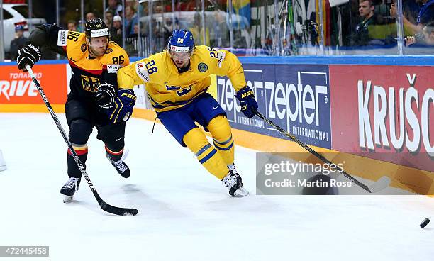 Elias Lindholm of Sweden and Daniel Pietta of Germany battle for the puck during the IIHF World Championship group A match between Sweden and Germany...
