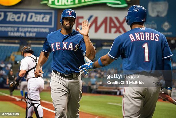 Carlos Peguero of the Texas Rangers is congratulated by Elvis Andrus of the Texas Rangers after scoring in the second inning against the Tampa Bay...