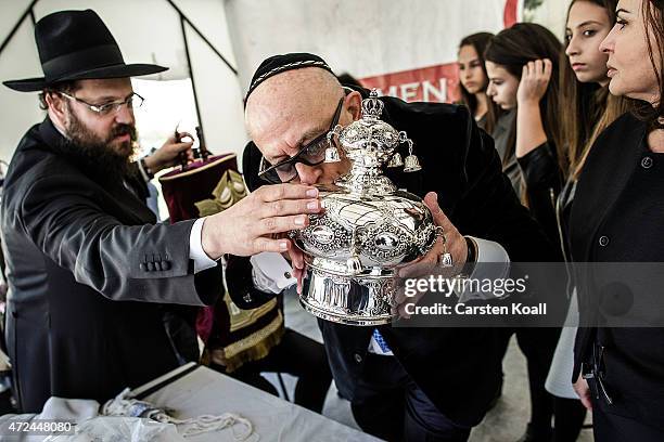 Jew kisses a crown after a scribe pens the final letters on a newly dedicated Torah scroll in the Chabad Synagogue on May 7, 2015 in Berlin, Germany....