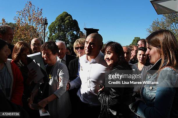 Michael Chan guides his mother Helena Chan through a crowd of mourners following the funeral service for executed Bali nine member Andrew Chan at...
