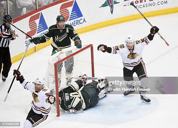 Brad Richards and Bryan Bickell of the Chicago Blackhawks celebrate a goal by teammate Patrick Kane as Ryan Suter and Ryan Suter of the Minnesota...