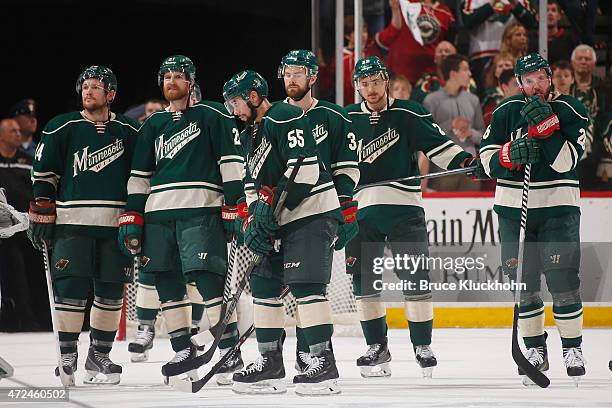 Matt Cooke, Kyle Brodziak, Mathew Dumba, Nate Prosser, Nino Niederreiter, and Thomas Vanek of the Minnesota Wild stand on the ice after being...