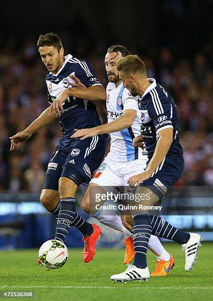Joshua Kennedy of City competes against Matthieu Delpierre and Nick Ansell of the Victory during the A-League semi final match between Melbourne...