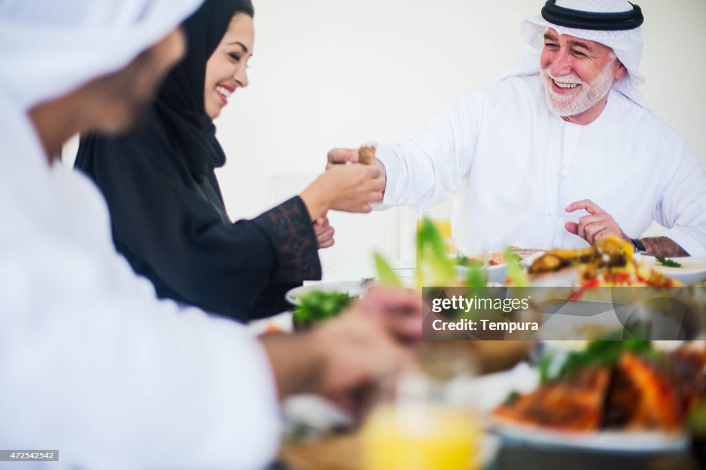 Family gathering, three generations eating traditional food.