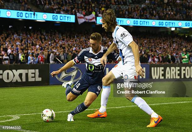 Nick Ansell of the Victory is challenged by Joshua Kennedy of Melbourne City during the A-League semi final match between Melbourne Victory and...