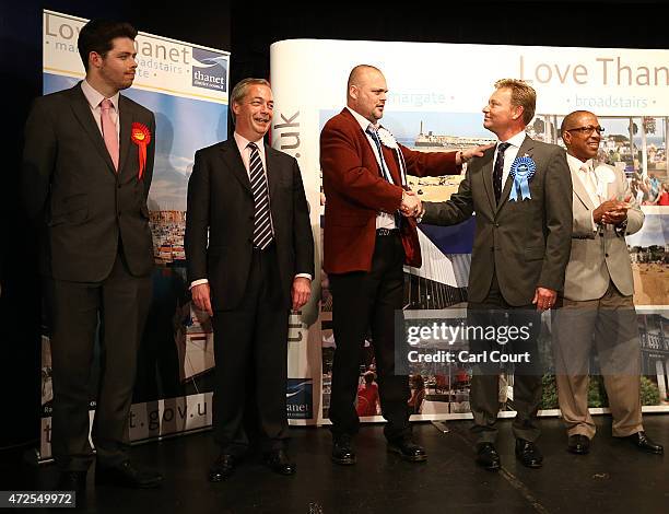 Leader Nigel Farage looks on Alastair James Hay, better known as comedian 'Al Murray' who portrays an English pub landlord congratulates Conservative...