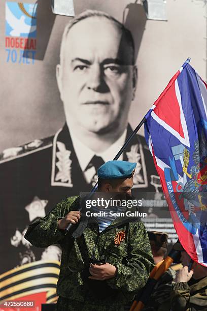 Militia cadet from the city of Lugansk in eastern Ukraine holds a pro-Russian separatist "Novorossiya" flag near a portrait of World War II Russian...