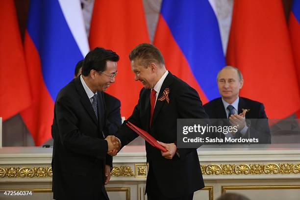 Gazprom's CEO Alexei Miller shakes hands with Vice-President of Chinese National Oil and Gaz Corporation Van Dunjing as they exchange documents...