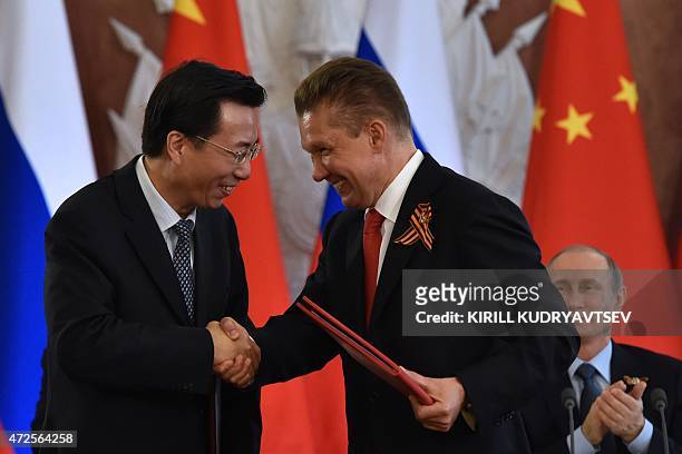 Russian gas giant Gazprom CEO Alexei Miller shakes hands with Vice President of CNPC, President of PetroChina Wang Dongjin during a signing ceremony...
