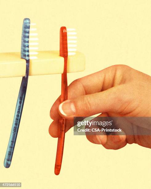 hand and two toothbrushes - holding toothbrush stock illustrations