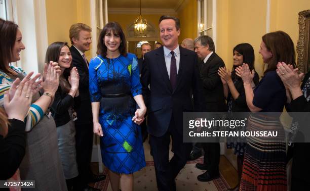 Britain's Prime Minister and Leader of the Conservative Party David Cameron and his wife Samantha are applauded by staff upon entering 10 Downing...
