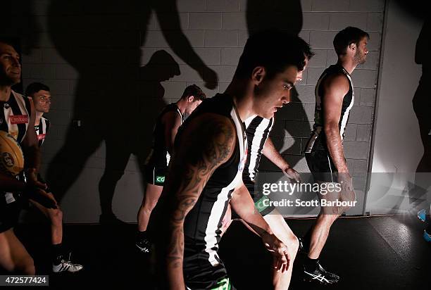 Nathan Brown, Marley Williams and the Magpies run onto the field during the round six AFL match between the Collingwood Magpies and the Geelong Cats...