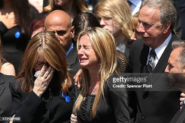 Family members grieve, including father Raymond, as the casket for fallen New York City police officer Brian Moore leaves a Long Island church on May...