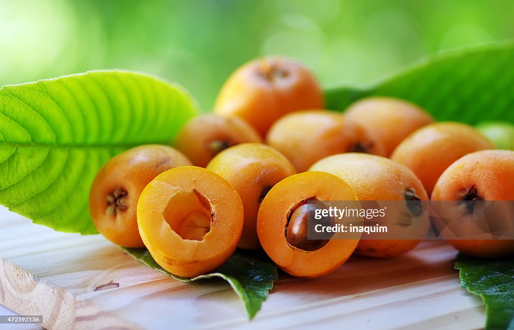 Loquat Medlar fruit isolated on a green background