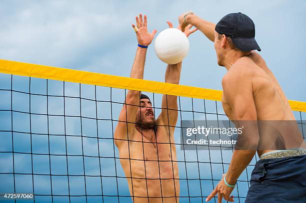 side view of attractive beach volley action on the net - beach volleyball team stock pictures, royalty-free photos & images