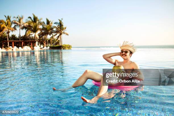 touristen in den swimmingpool - kokosnüsse stock-fotos und bilder