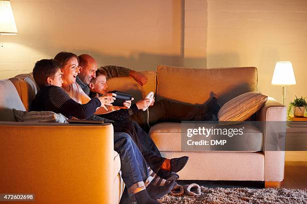 happy family playing video game at home - family game night stock pictures, royalty-free photos & images