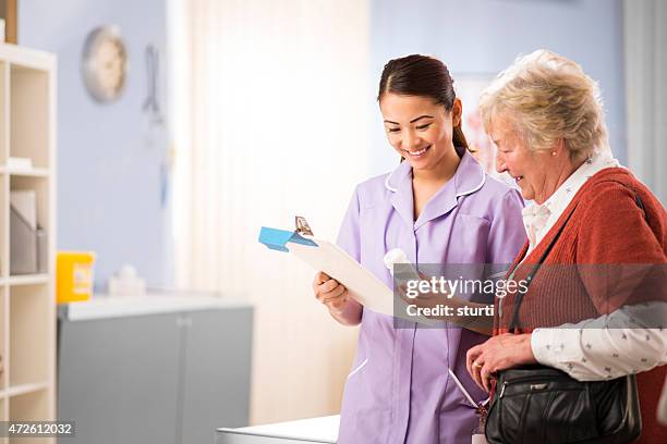 nurse chats to senior patient - outpatient care stock pictures, royalty-free photos & images