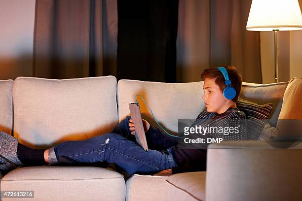 boy escuchar música de tableta digital - youth 2015 film fotografías e imágenes de stock