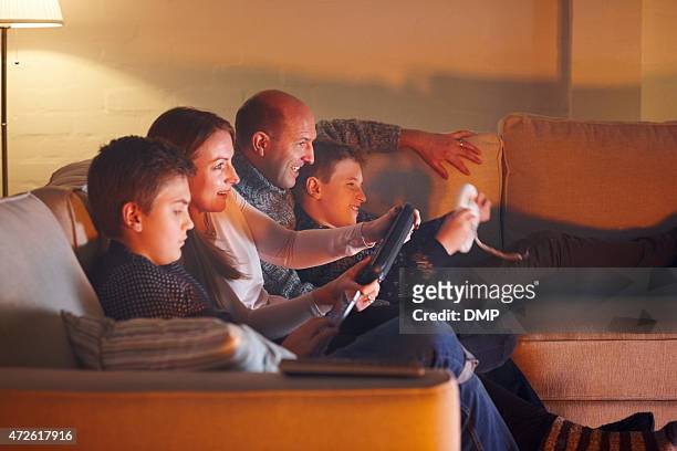happy family having fun playing video games - family game night stock pictures, royalty-free photos & images