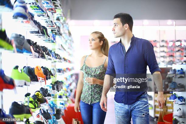 two people buying shoes in retail store. - footwear retail stock pictures, royalty-free photos & images