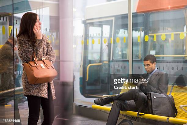 bus station office workers texting - bus shelter stock pictures, royalty-free photos & images