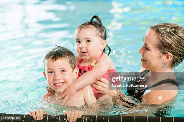 mother swimming with children - kid bath mother stock pictures, royalty-free photos & images