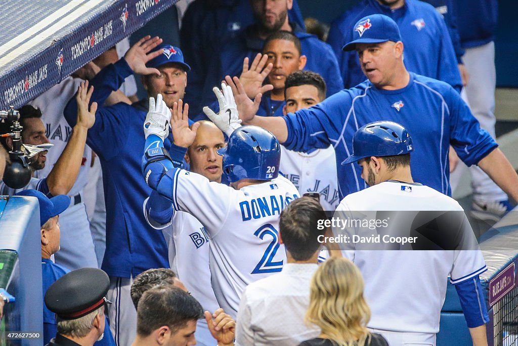 Josh Donaldson (20) of the Toronto Blue Jays gets high fives in the dug out after homering in the first inning