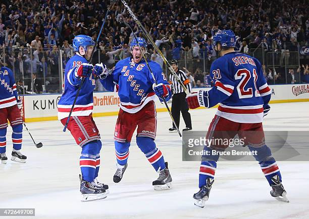 Ryan McDonagh of the New York Rangers celebrates his game winning goal at 9:37 of overtime against the Washington Capitals and is joined by Jesper...