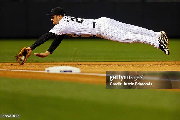 Third baseman Nolan Arenado of the Colorado Rockies dives on an infield hit by Alex Guerrero of the Los Angeles Dodgers during the first inning at...