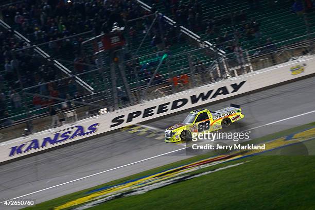 Matt Crafton, driver of the Slim Jim/Menards Toyota, takes the checkered flag to win the NASCAR Camping World Truck Series Toyota Tundra 250 at...