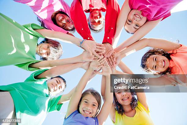 group of children in a circle - handen ineengevouwen stockfoto's en -beelden