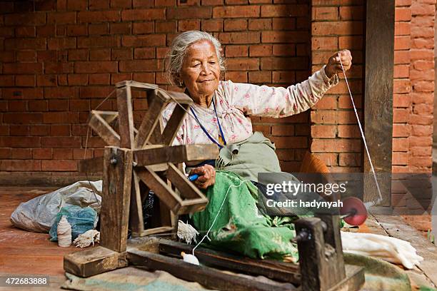 nepali frau spinning der wolle.   bhaktapur - spinnrad stock-fotos und bilder