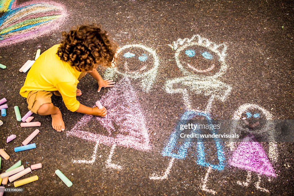 Boy Drawing A Colourful Chalk Picture Of His Family High-Res Stock