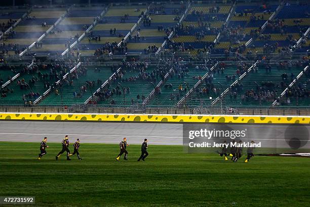 The team of Matt Crafton, driver of the Slim Jim/Menards Toyota, runs to celebrate after winning the NASCAR Camping World Truck Series Toyota Tundra...