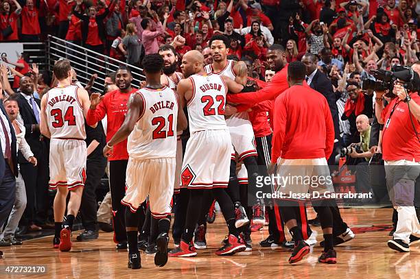 Derrick Rose of the Chicago Bulls celebrates with teammates after hitting the game winning three pointer with three seconds left in the game against...