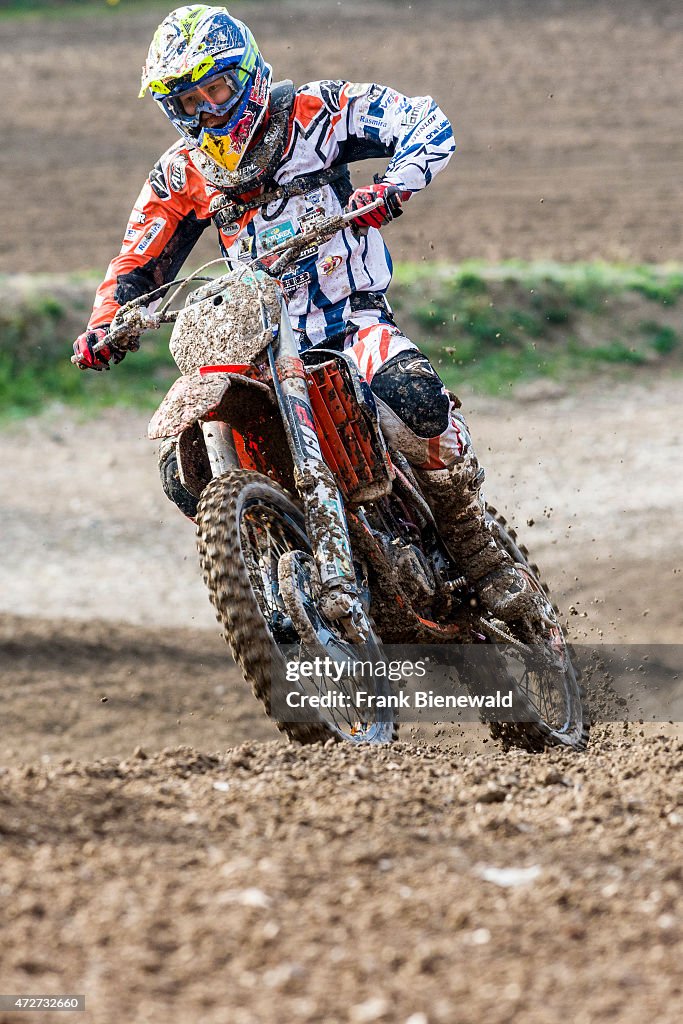 A motorcyclist on a motocross bike is riding on a dirt track...