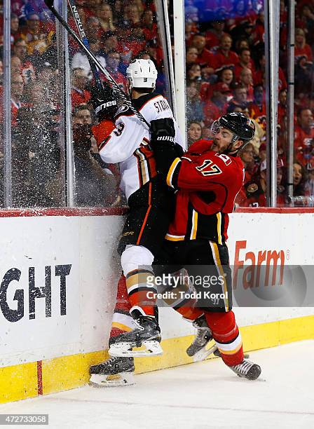 Lance Bouma of the Calgary Flames hits Clayton Stoner of the Anaheim Ducks against the boards in Game Four of the Western Conference Semifinals...