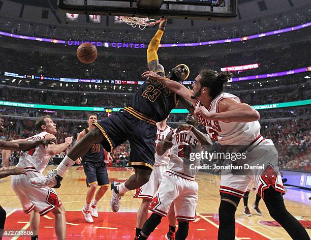 LeBron James of the Cleveland Cavaliers dunks over Mike Dunleavy, Jimmy Buter and Joakim Noah of the Chicago Bulls in Game Three of the Eastern...