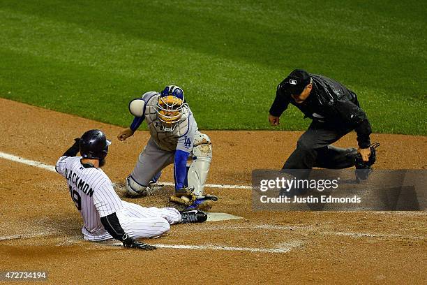 Catcher Yasmani Grandal of the Los Angeles Dodgers tags out Charlie Blackmon of the Colorado Rockies at home plate during the fifth inning as home...