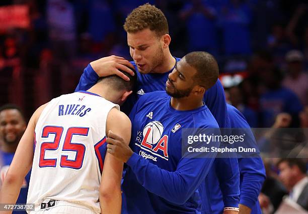 Austin Rivers of the Los Angeles Clippers is embraced by Blake Griffin and Chris Paul during a time out against the Houston Rockets during Game Three...