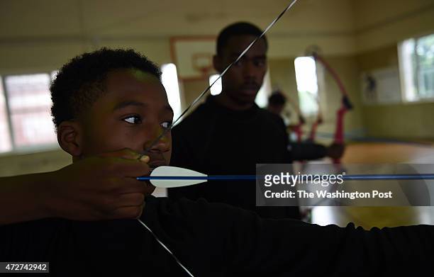 Karlos Kinney aims his bow and arrow during archery class at Roosevelt High School.