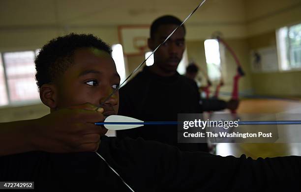 Karlos Kinney aims his bow and arrow during archery class at Roosevelt High School.