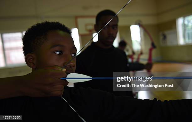 Karlos Kinney aims his bow and arrow during archery class at Roosevelt High School.