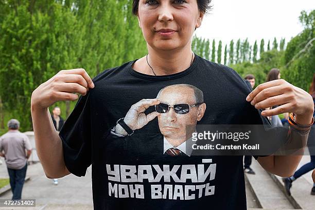 Woman shows a shirt with the face of Vladimir Putin on Victory Day, when Nazi Germany surrendered to the Soviet Union at the Soviet war cemetery and...