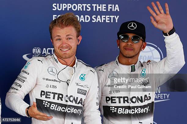 Nico Rosberg of Germany and Mercedes GP waves to the crowd next to Lewis Hamilton of Great Britain and Mercedes GP after claiming pole position...