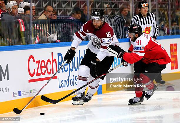 Dominique Heinrich of Austria and Kaspars Daugavins of Latvia battle for the puck during the IIHF World Championship group A match between Austria...