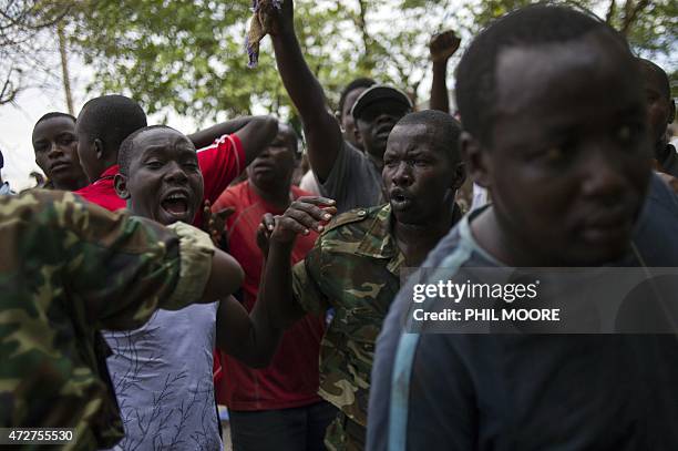 Burundian soldiers hold back civilians after they caught a man accused of being an "Imbonerakure", a member of the ruling CNDD-FDD party's youth wing...