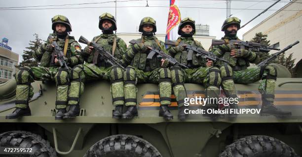 Pro-Russian separatists of the self-proclaimed Donetsk People's Republic sit atop a self-propelled gun during the Victory Day parade in Donetsk on...